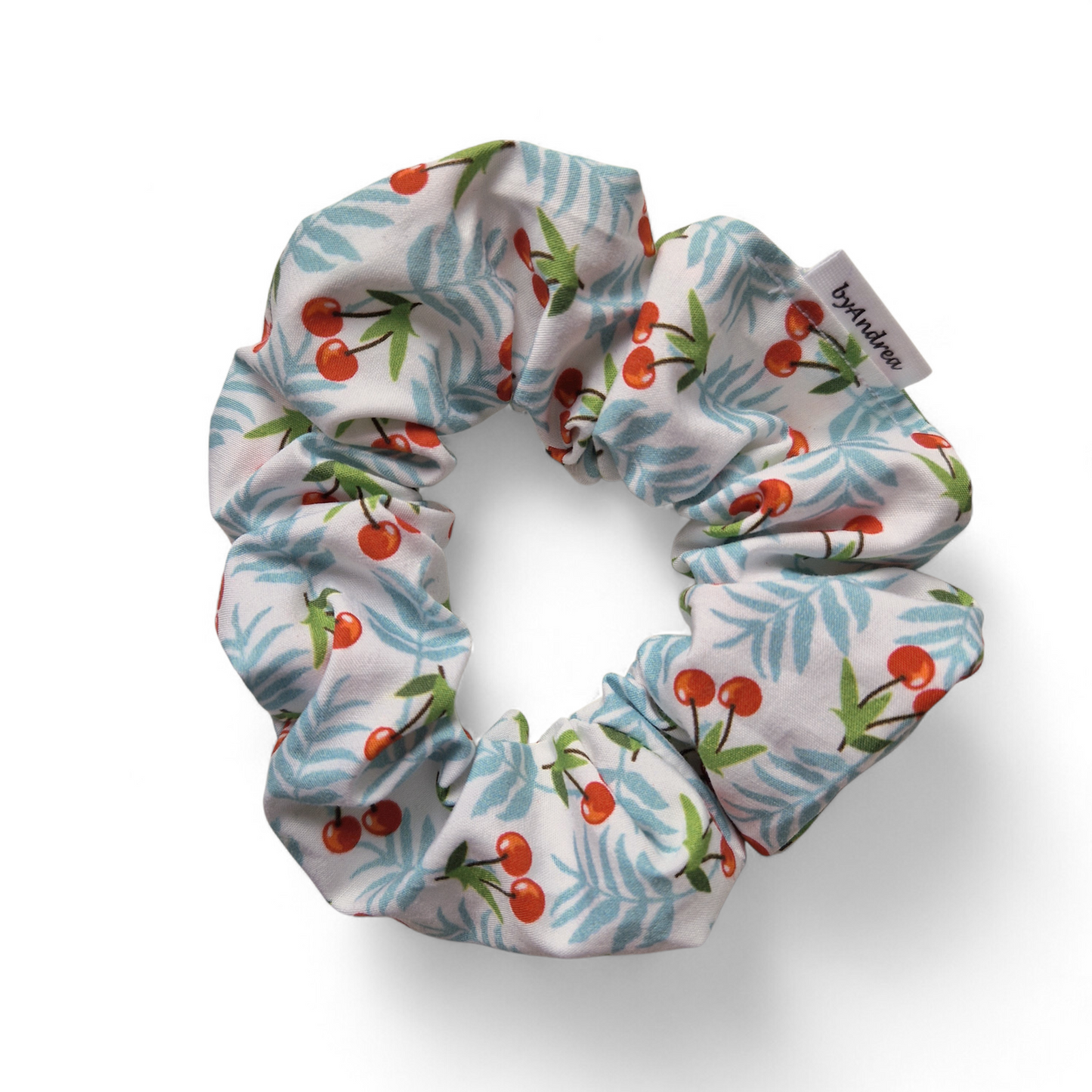 Scrunchie kirsebær og blader på hvit bakgrunn