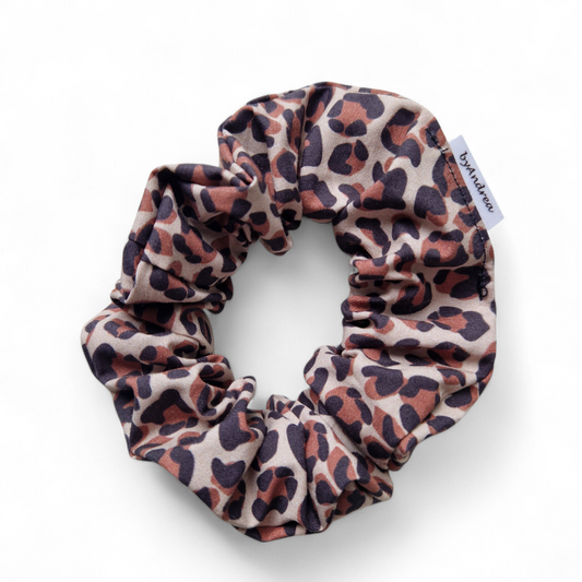 Scrunchie leopardmønster på beige bakgrunn
